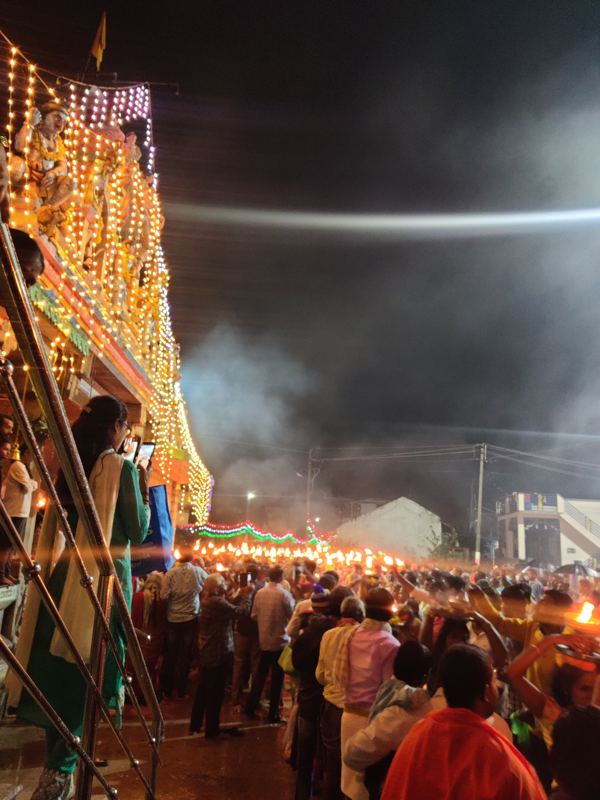 ಸಾವಿರಾರು ದೀಪಗಳಿಂದ ಅಲಂಕರಿಸಿದ ದೇವಸ್ಥಾನದ ಗೋಪುರದ ಪಕ್ಕದಲ್ಲಿ ಆರತಿ ಮೆರವಣಿಗೆ